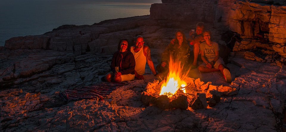 people sitting around campfire